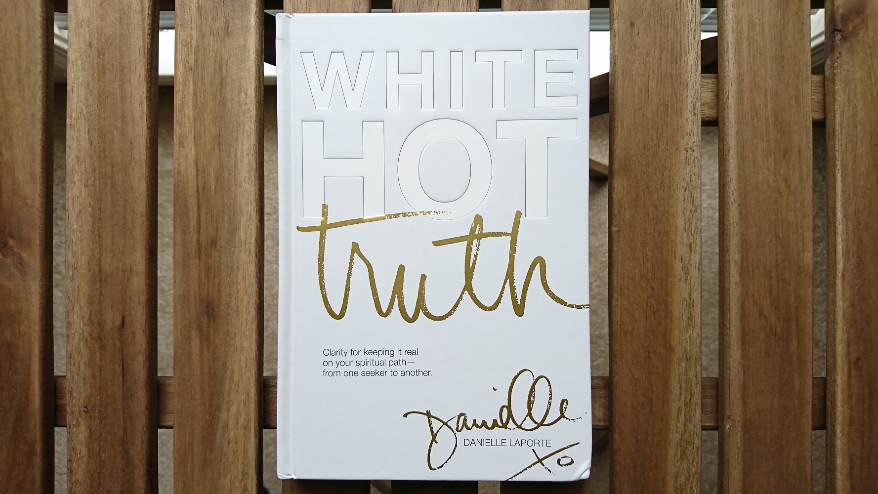 photo of the book White Hot Truth by Danielle LaPorte with an all white cover and the first 2 words of the title embossed and the 3rd word of the title in gold.